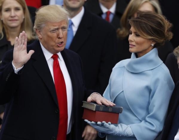 Donald Trump takes the oath of office as his wife Melania holds a bible during his inauguration as the 45th president of the United States on the West front of the U.S. Capitol in Washington, U.S., January 20, 2017. REUTERS/Lucy Nicholson